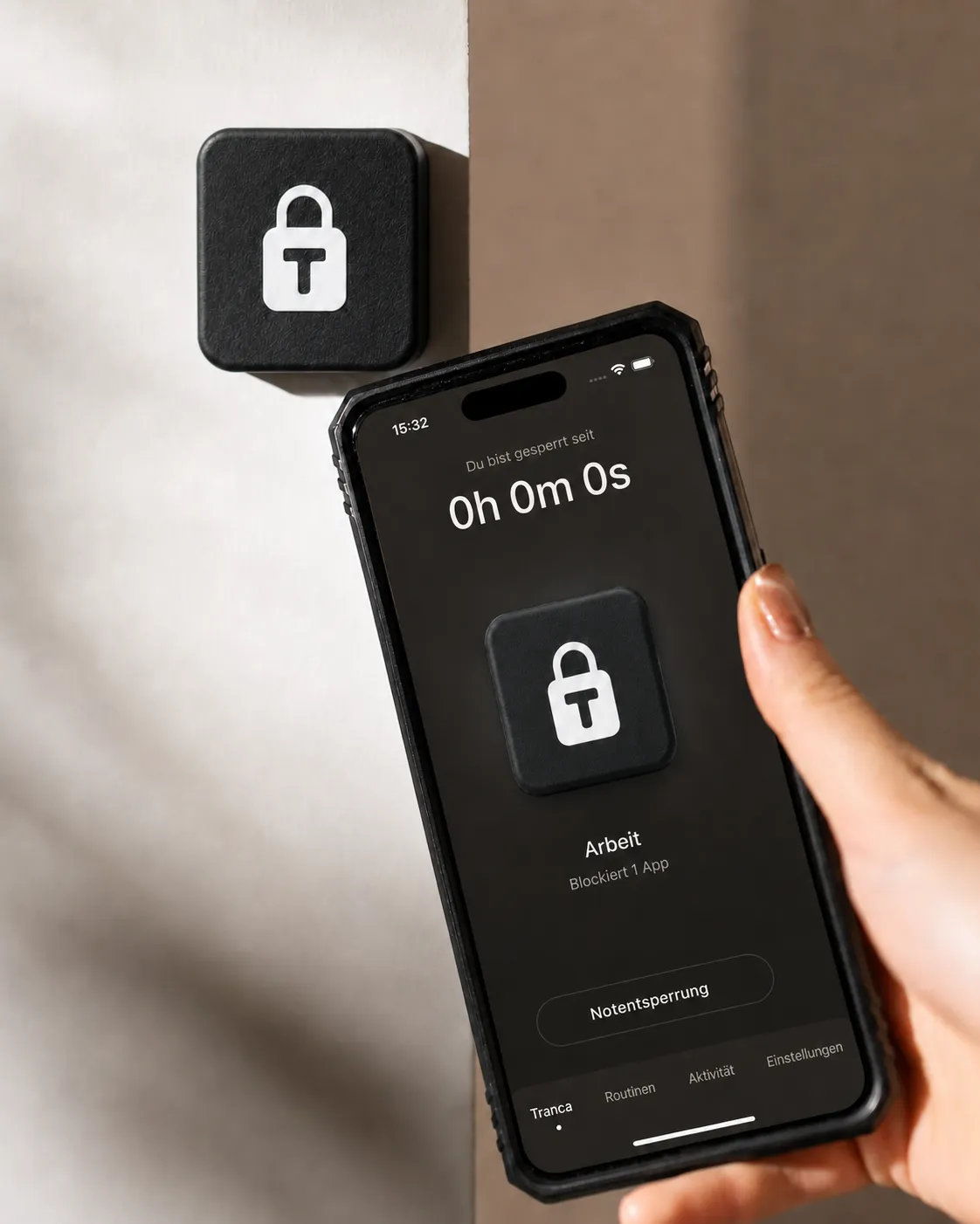 Tranca an der Wand und ein Handy in der Hand mit aktivem Fokus-Profil